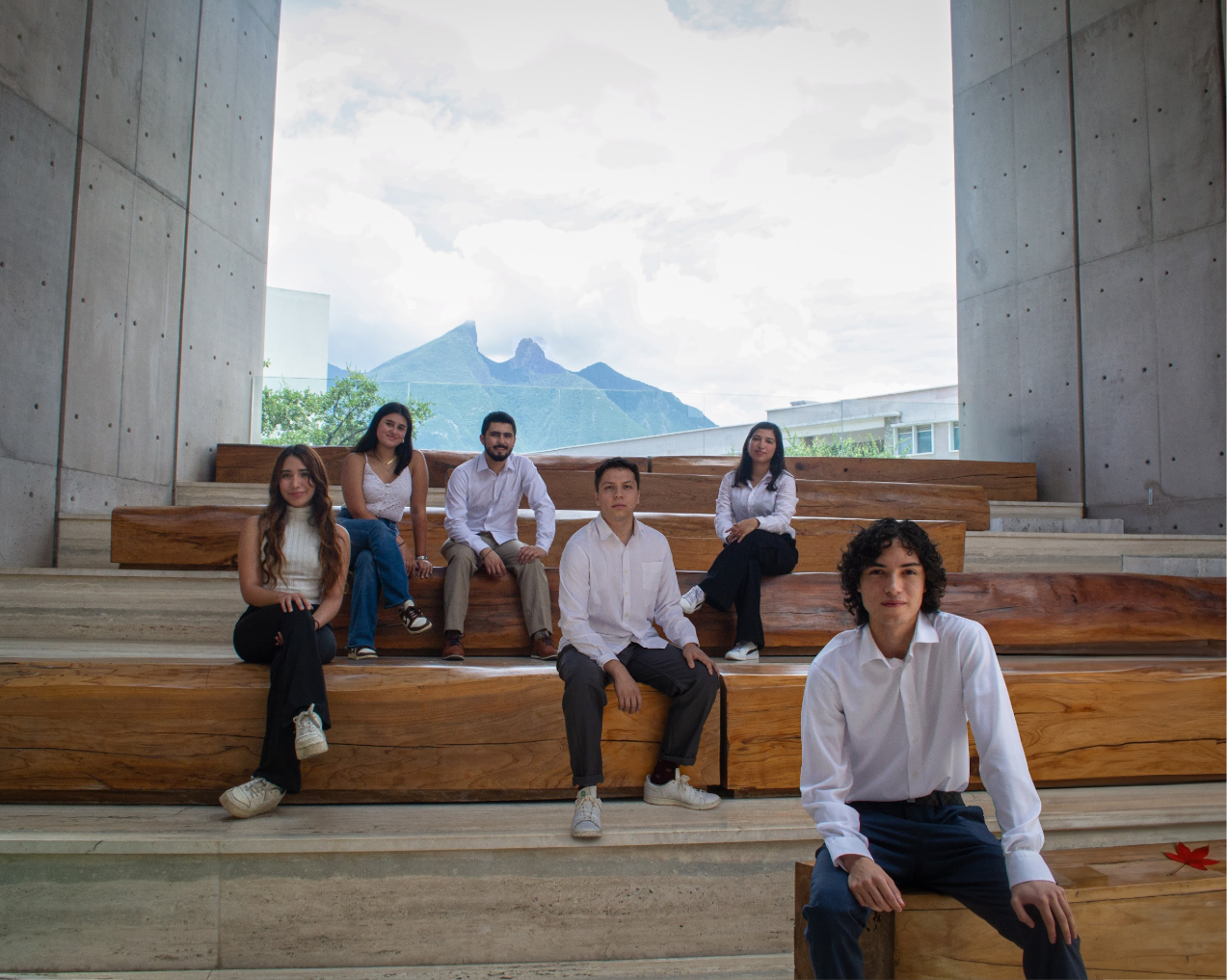 The AECAN board seated on concrete steps with Cerro de la Silla framed behind them