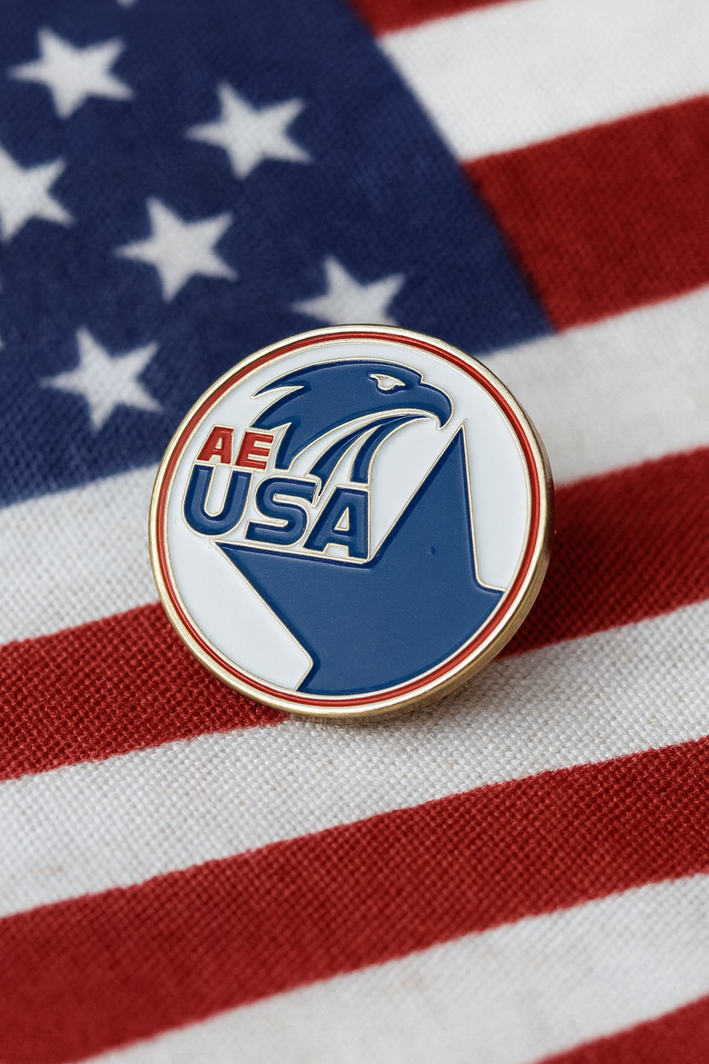 AEUSA eagle enamel lapel pin resting on an American flag