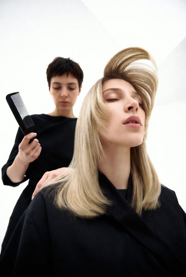 Editorial salon portrait: a stylist combing a client's hair in a bright studio