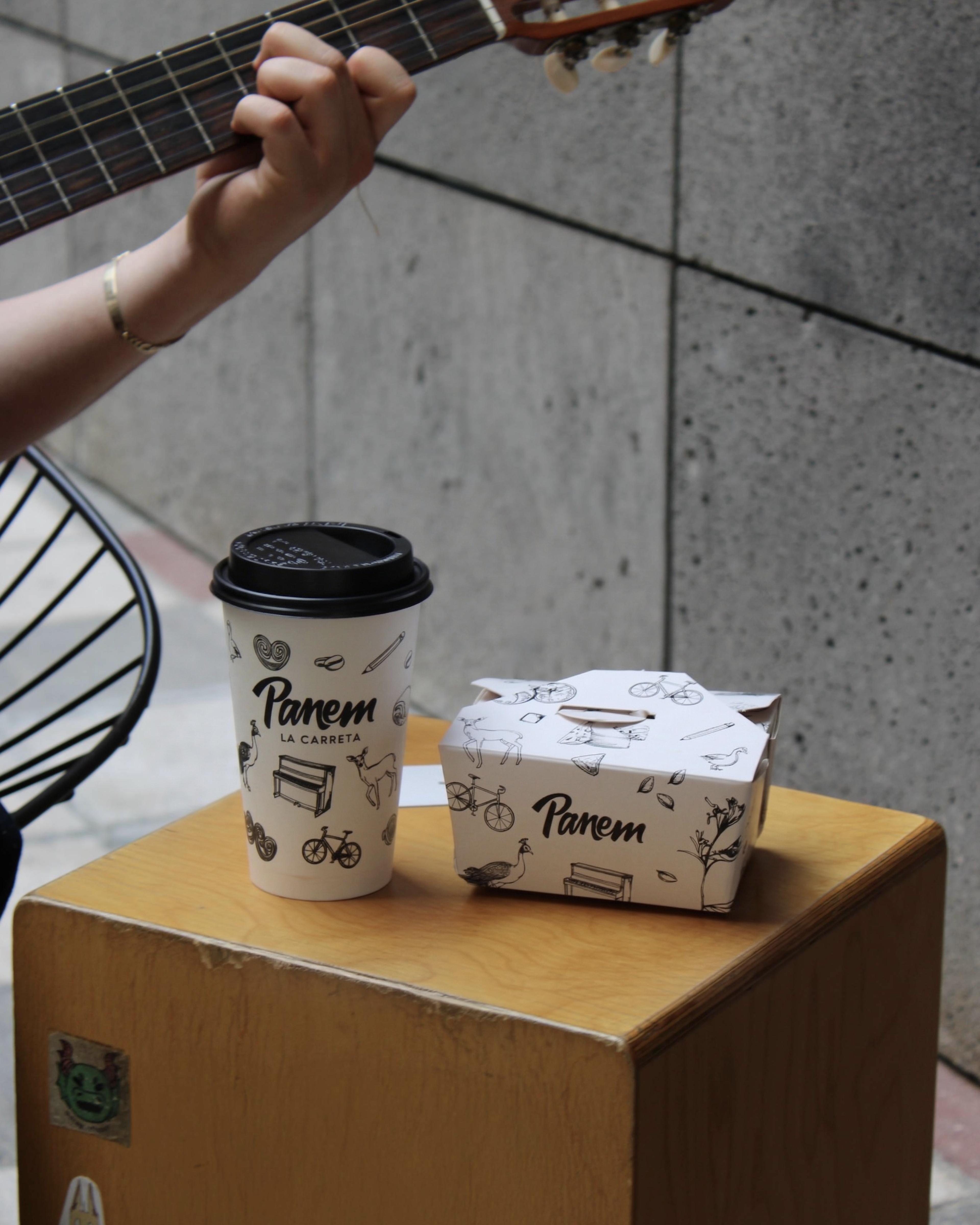 Panem cup and box beside a guitar on the street